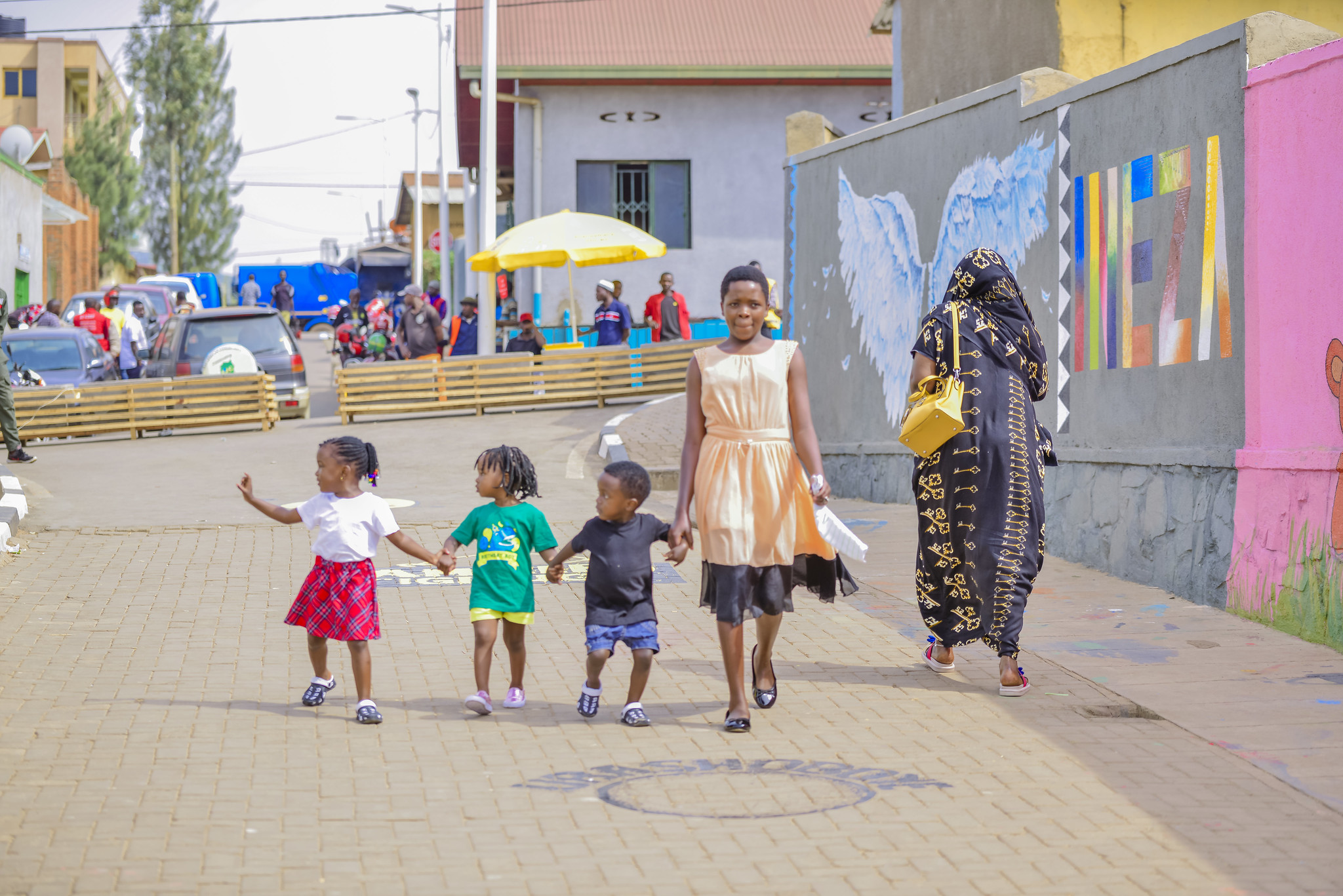 Gadis dan anak-anak berjalan di jalan pejalan kaki di Kigali, Rwanda