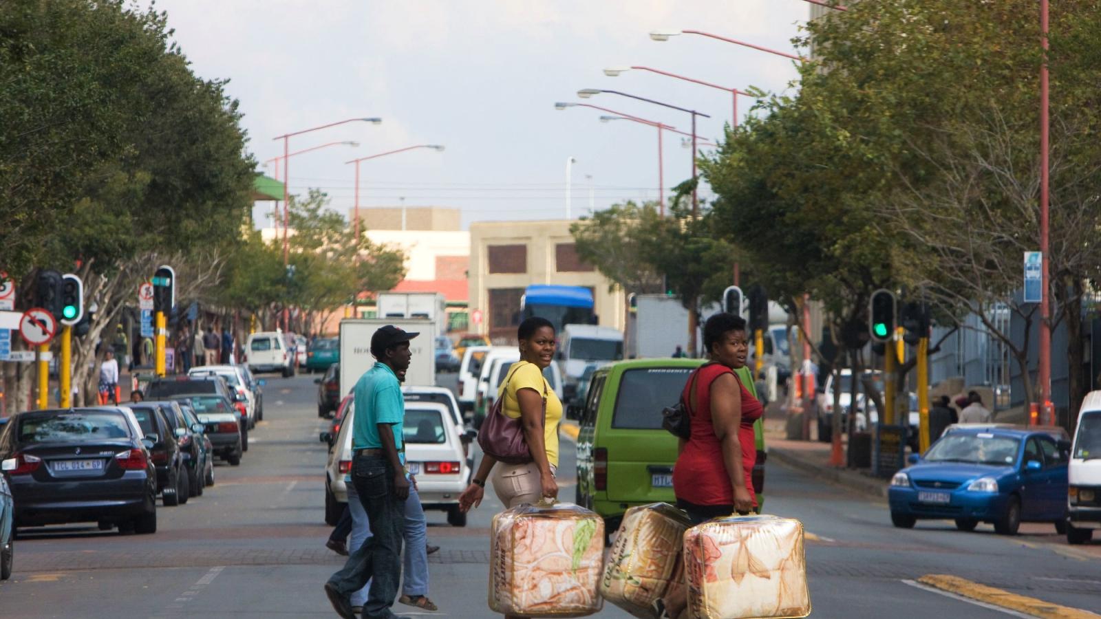 Orang-orang yang menyeberang jalan yang sibuk di Johannesburg Afrika Selatan
