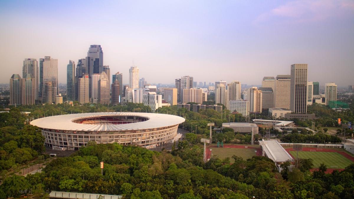 Pemandangan Stadion Gelora Bung Karno di Jakarta yang dikelilingi pepohonan dan cakrawala kota