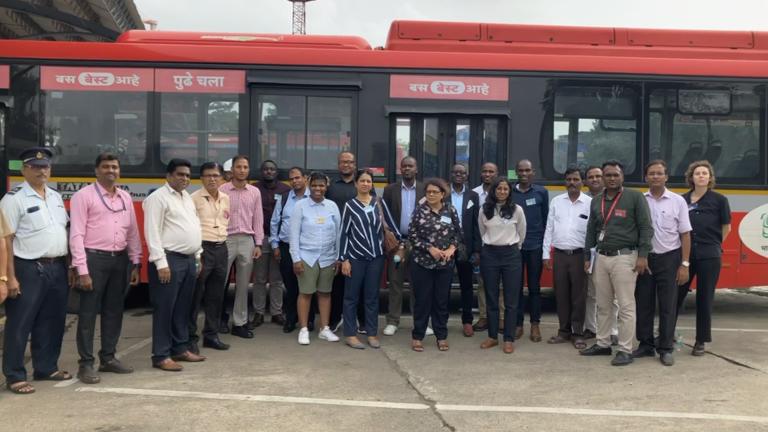 Para peserta pertukaran UrbanShift Peer to Peer di depan bus tanpa emisi di Mumbai