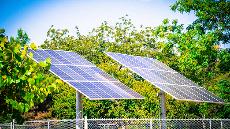 panel surya di depan pepohonan hijau