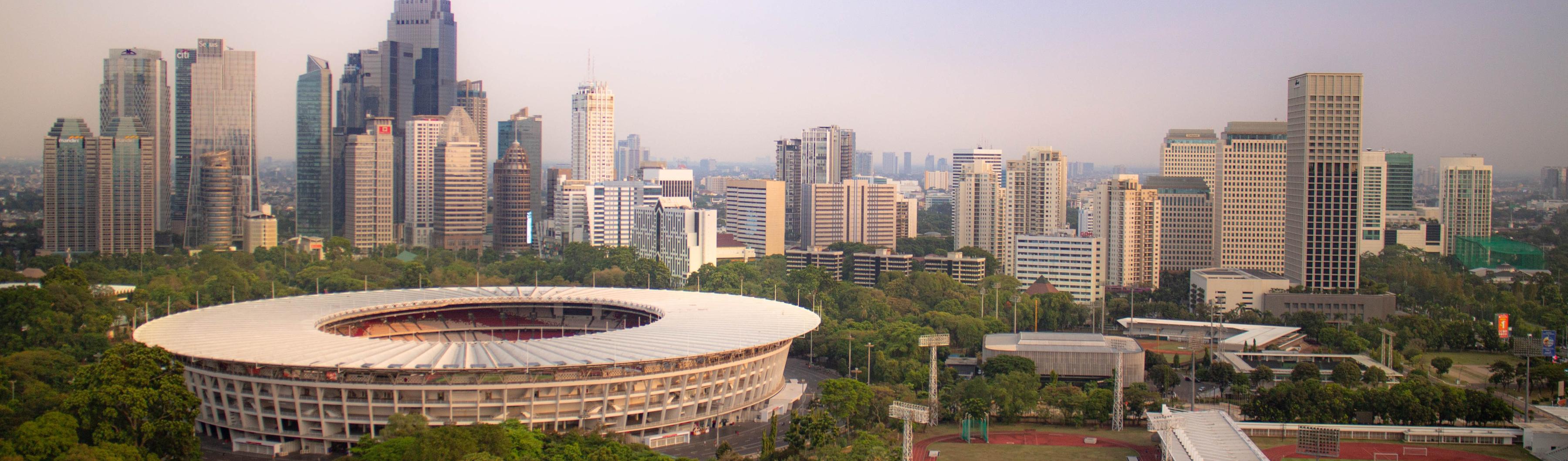 Pemandangan Stadion Gelora Bung Karno di Jakarta yang dikelilingi pepohonan dan cakrawala kota